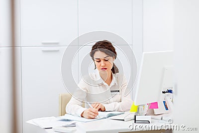 Friendly young woman behind reception desk administrator Stock Photo