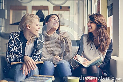 Friends in cafe. Three best friend having funny conversation. Stock Photo