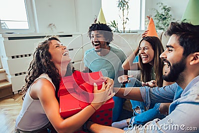 Friends celebrating birthday and giving gift to a girl Stock Photo