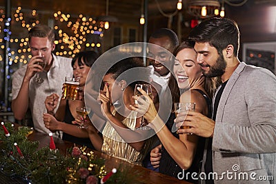 Friends celebrating together at a Christmas party in a bar Stock Photo