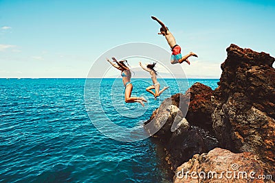 Friends cliff jumping into the ocean Stock Photo