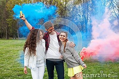 Friends with colored smoke on lawn Stock Photo