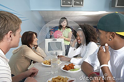 Friends Eating At Bowling Alley Stock Photo