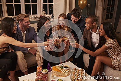 Friends Eating Snacks As They Celebrate At Party Together Stock Photo