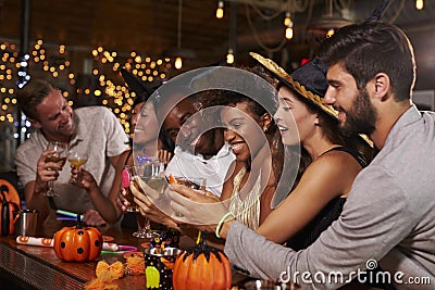 Friends enjoying a Halloween party at a bar making a toast Stock Photo