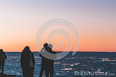 Friends enjoying a sunset by the sea Editorial Stock Photo