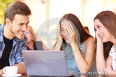 Friends giving a laptop gift to a surprised girl Stock Photo