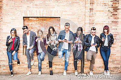 Friends group using smartphone against wall at university college Stock Photo