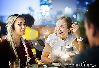 Friends having a dinner together at a rooftop bar Stock Photo