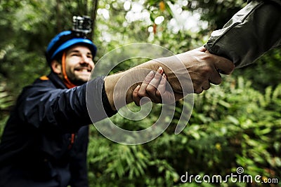 Friends helping each other while trekking Stock Photo