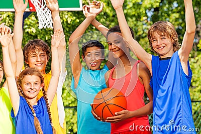 Friends hold arms up at basketball game Stock Photo