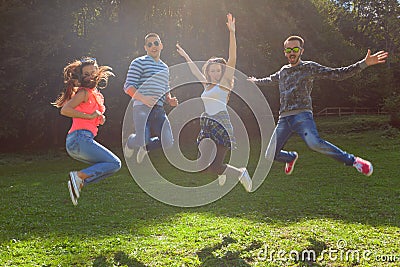 Friends jumping and having fun at sunny day Stock Photo