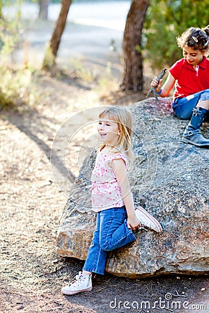 Friends kid girls playing in forest rock Stock Photo