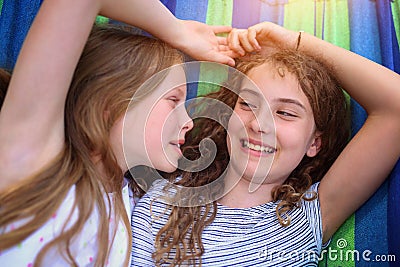Friends are laughing on a hammock on a hot sunny day Stock Photo