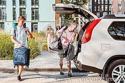 friends load car trunk with baggage Stock Photo