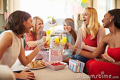 Friends Making A Toast With Orange Juice At Baby Shower Stock Photo