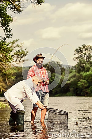 Friends men with fishing rod and net. Fly fishing adventures. happy fishermen. Good profit. retired dad and mature Stock Photo