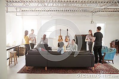 Friends at a party in a New York loft apartment, full length Stock Photo