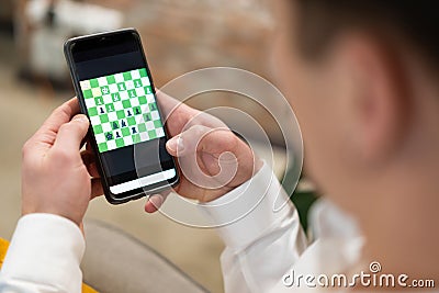 Friends play chess on their smartphones online Stock Photo