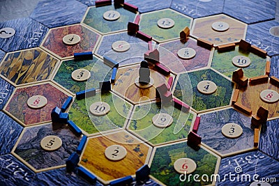 Friends playing settlers of catan board game Editorial Stock Photo