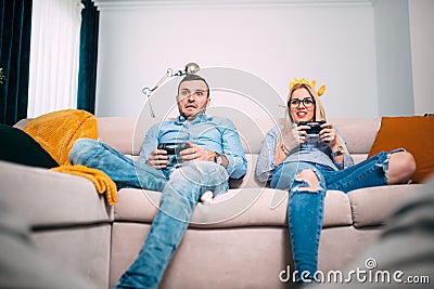 Friends playing video games with joystick Controllers. Young people having fun with modern technology and playing on console Stock Photo