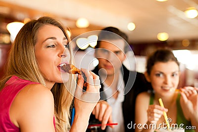 Friends in Restaurant eating fast food Stock Photo