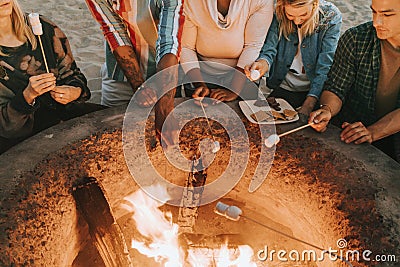 Friends roasting marshmallows for s`mores Stock Photo