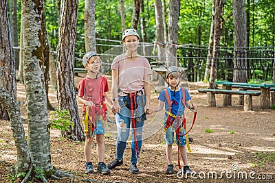 Friends on the ropes course. Young people in safety equipment are obstacles on the road rope Stock Photo
