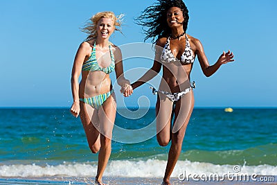 Friends running on beach vacation Stock Photo