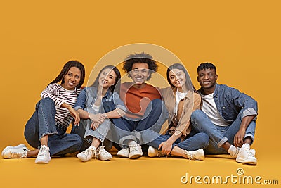 Friends seated together casually on the floor Stock Photo