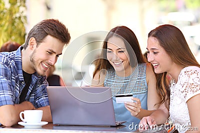 Friends shopping online with a credit card and a laptop Stock Photo