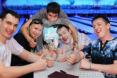 Friends sit at table and thumb up in bowling Stock Photo