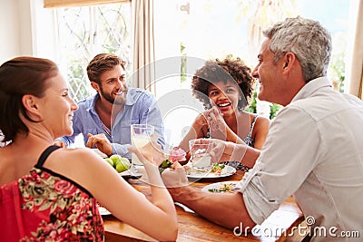 Friends sitting at a table talking during a dinner party Stock Photo