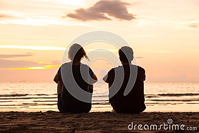 Friends sitting together on the beach Stock Photo