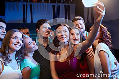 Friends with smartphone taking selfie in club Stock Photo