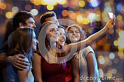 Friends with smartphone taking selfie in club Stock Photo