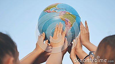 Friends spin the globe high above them. Stock Photo