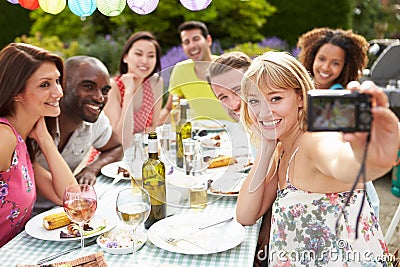 Friends Taking Self Portrait On Camera At Outdoor Barbeque Stock Photo