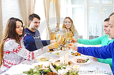 Friends toasting with champagne while having Christmas dinner Stock Photo