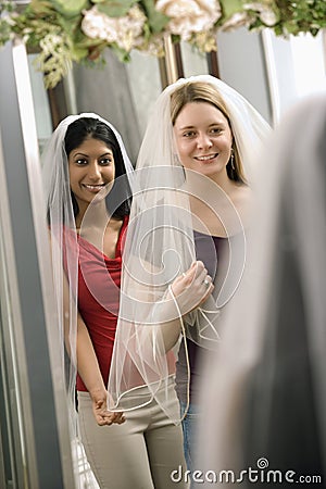 Friends trying on veils. Stock Photo