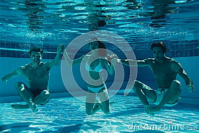 Friends under water in swimming pool Stock Photo