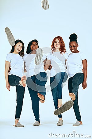 Two multicultural couples of women in casuals looking happy together on white Stock Photo