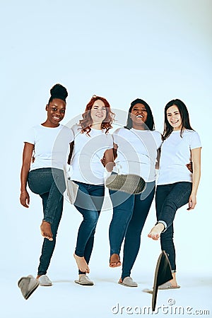 Two multicultural couples of women in casuals looking happy together on white Stock Photo
