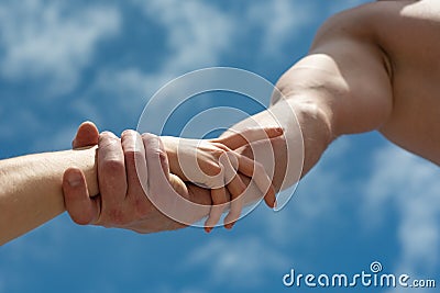 Friendship and help. Support. Two hands on sky background. Man and woman. Stock Photo