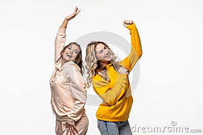 friendship, people and appiness concept. Two happy dancing girls on white background Stock Photo