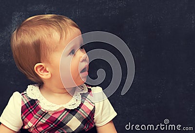 Frightened baby girl with chalk at a school board Stock Photo