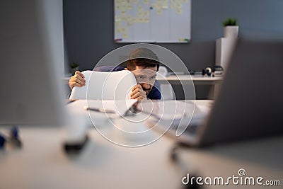 Frightened Businessman Hiding Behind Chair Stock Photo