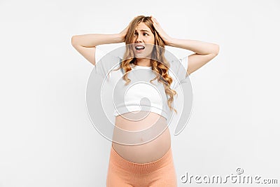 Frightened unsure pregnant woman standing . Nervous excited woman experiences before childbirth Human emotions Stock Photo