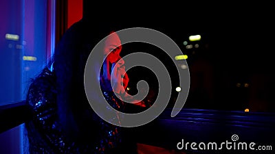 Frightened woman calling police, informing about disorder at night private party Stock Photo