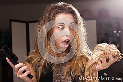Frightened pretty girl discovering hair loss on a hairbrush Stock Photo